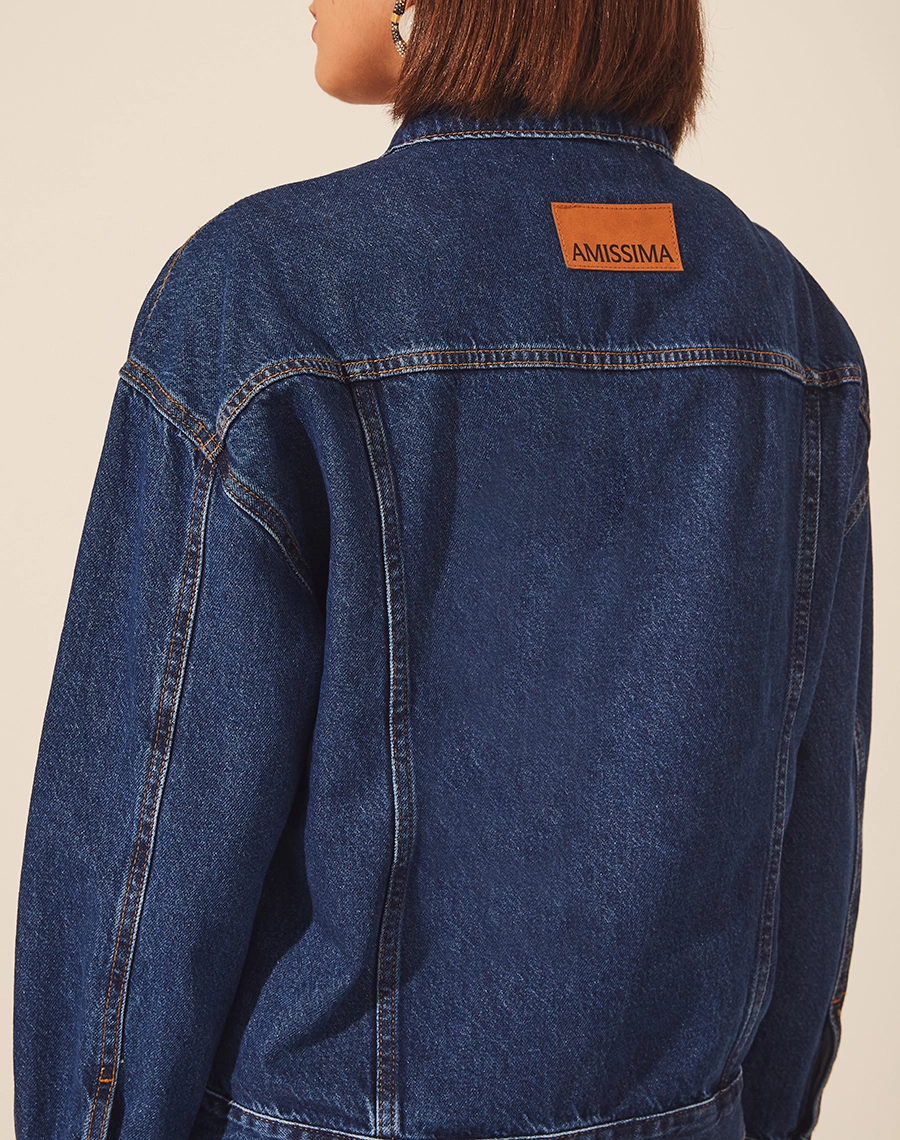 Jaqueta Jeans Oversized, com gola esportiva e dois bolsos frontais. <br/>
Fechamento por botões de metal. <br/>
