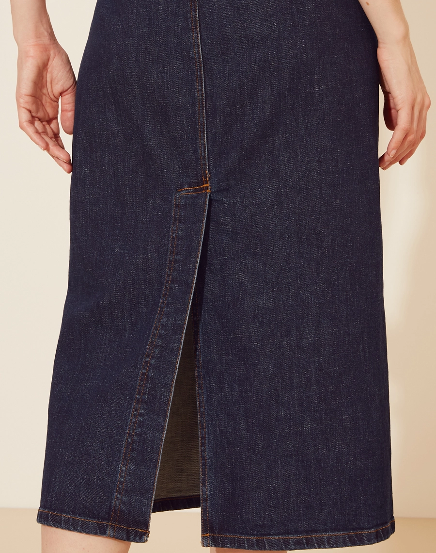 Saia  Jeans Midi confeccionada em algodão. <br/> 
Cintura alta e cós com passantes.Dois bolsos frontais e dois bolsos quadrados atrás.<br/> 
Possui fenda  e seu fechamento frontal por zíper e botão de casa.<br/> 
