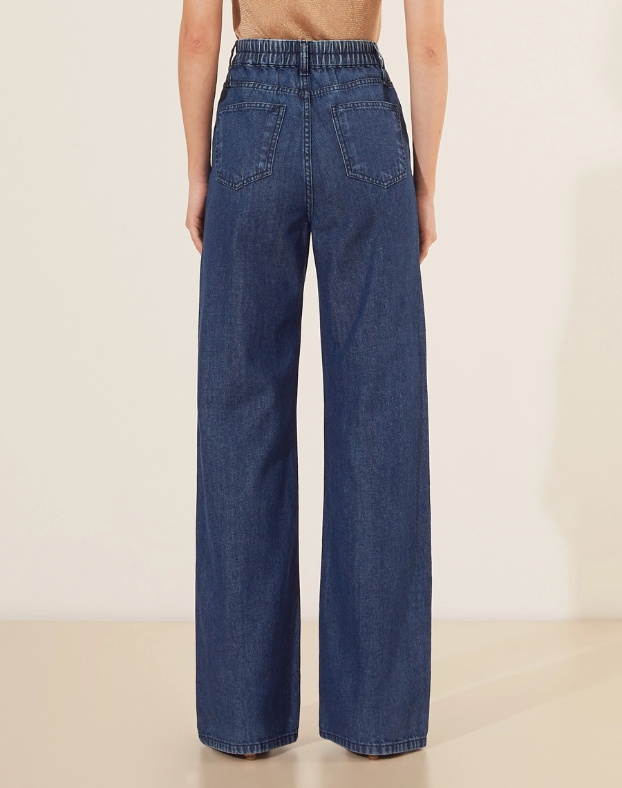 Calça Flare Karolaine confeccionada em jeans de lavagem escura. Ideal para compor looks modernos com blusas justas ou camisetas mais soltas.