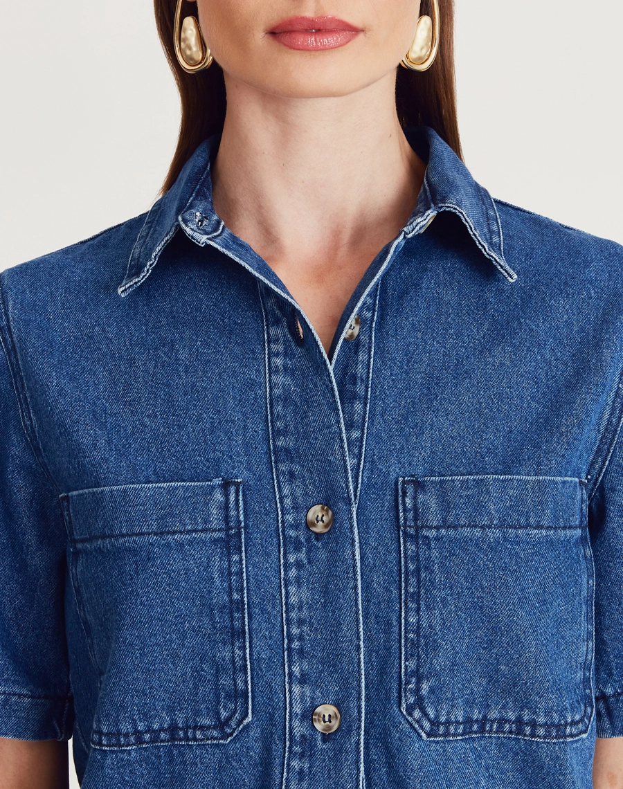 Camisa Bonnie confeccionada em jeans com lavagem escura. Versátil, pode ser usada aberta como sobreposição ou fechada, compondo combinações modernas e despojadas.