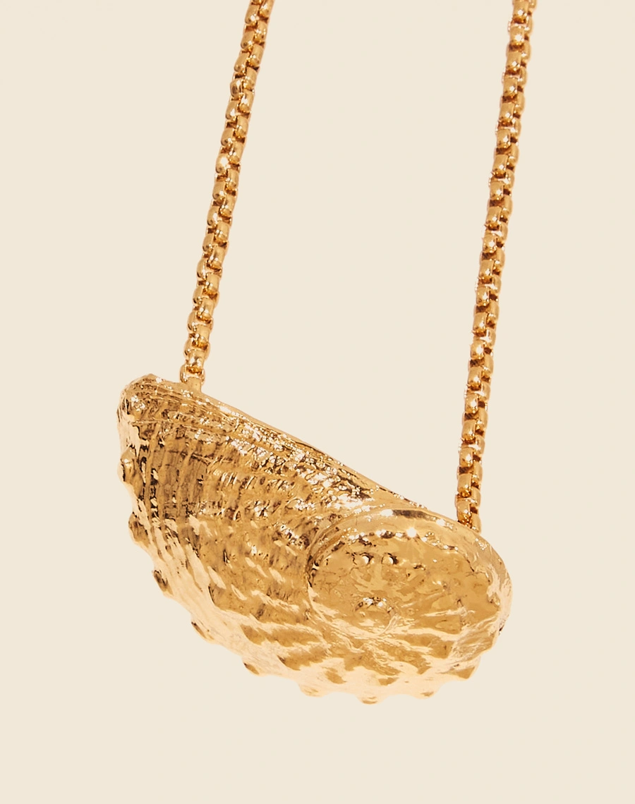 Colar Mermaid City  é uma peça artesanal banhada a ouro,feita manualmete  com uma corrente elegante que apresenta um pingente de metal em forma de concha abalone.<br/>
