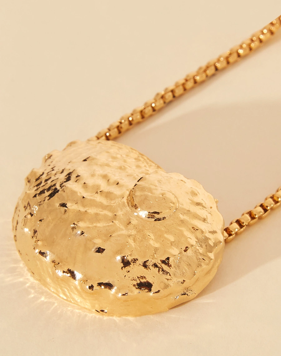 Colar Mermaid City  é uma peça artesanal banhada a ouro,feita manualmete  com uma corrente elegante que apresenta um pingente de metal em forma de concha abalone.<br/>