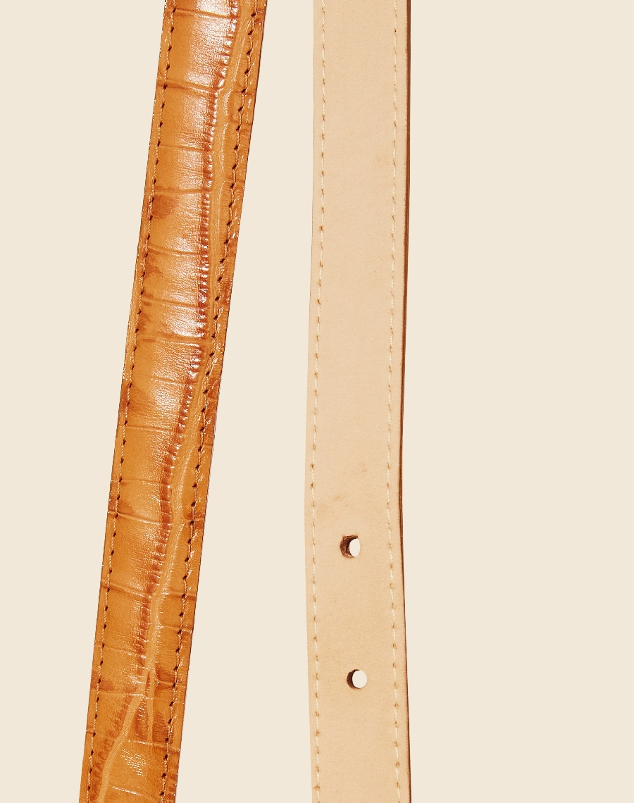 Um cinto de design classico feito de couro croco, com uma fivela marcante. Sua parte interna é forrada de nobuck, proporcionando um toque suave e confortável.