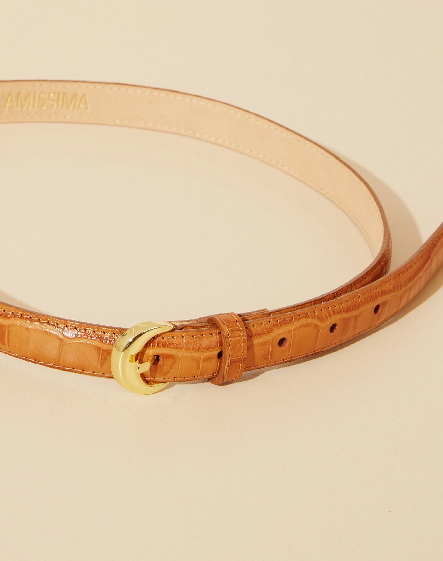 Um cinto de design classico feito de couro croco, com uma fivela marcante. Sua parte interna é forrada de nobuck, proporcionando um toque suave e confortável.