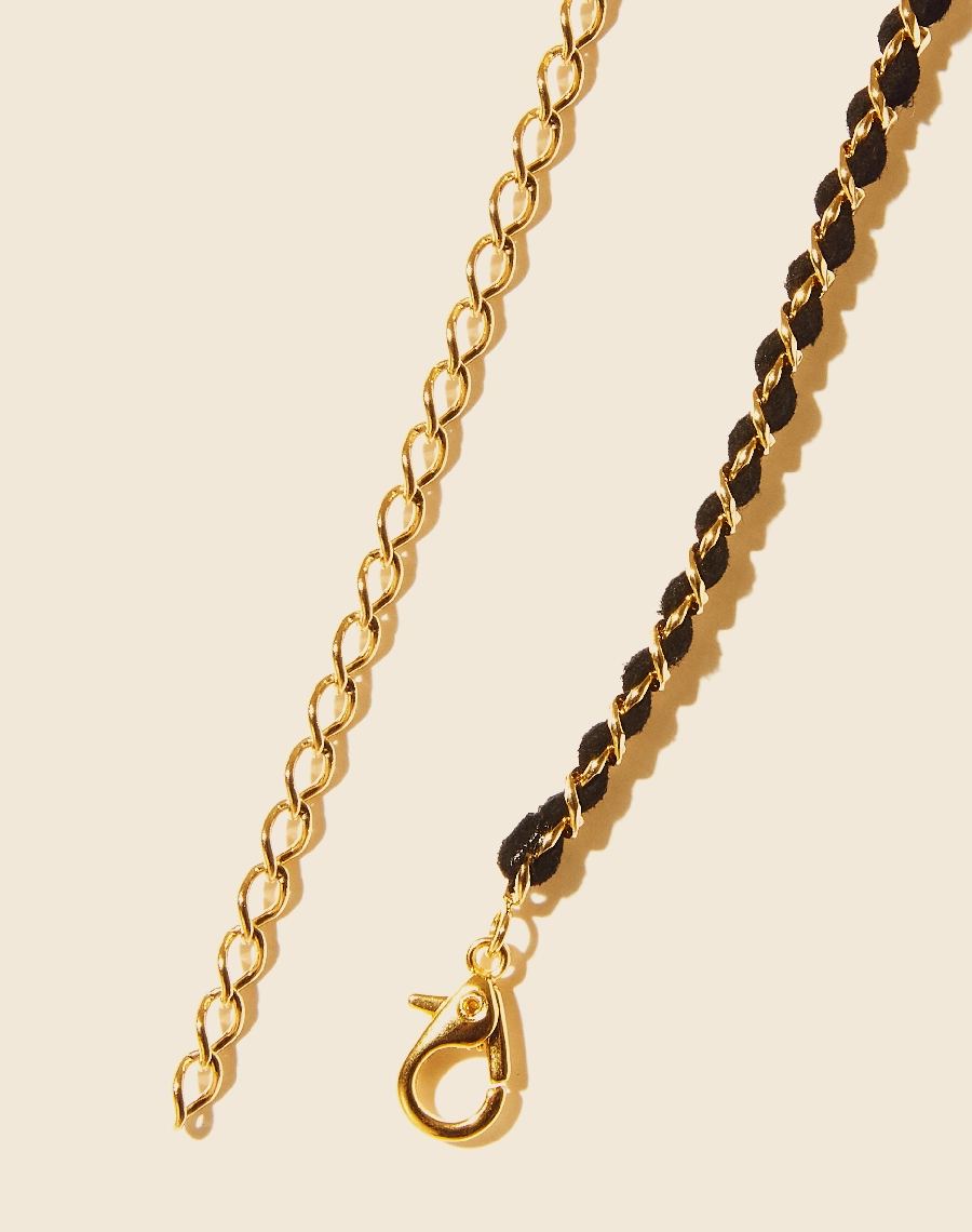 Colar Heart Chain confeccionado manualmente em corrente de elo grumet banhada a ouro com fio de couro e pingente frontal de pérola shell. <br/>
Possui fecho lagosta para regulagem.