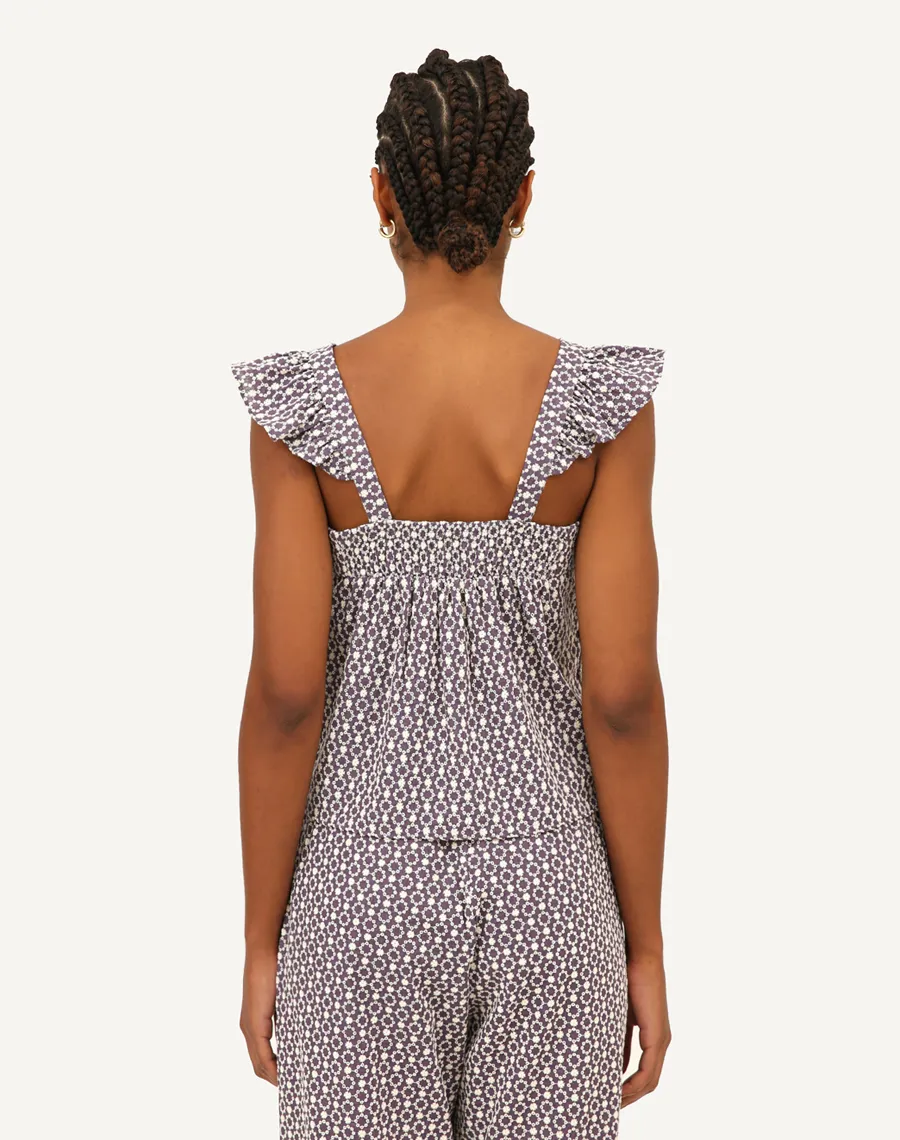 Blusa confeccionada em cambraia bordada mista de algodão e poliéster. Possui detalhes de babado nas alças e elastex nas costas.