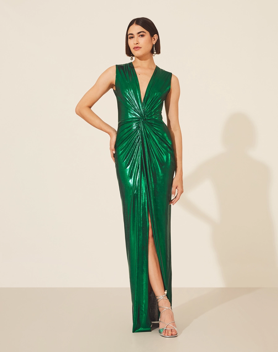 Vestido Lamê Oscar confeccionado em Malha Foil,  possuí decote V com detalhe torcido até a cintura.<br/>
Com forro curto e saia com fenda. Possui modelagem mais justa e seu fechamento é por zíper invisível lateral.