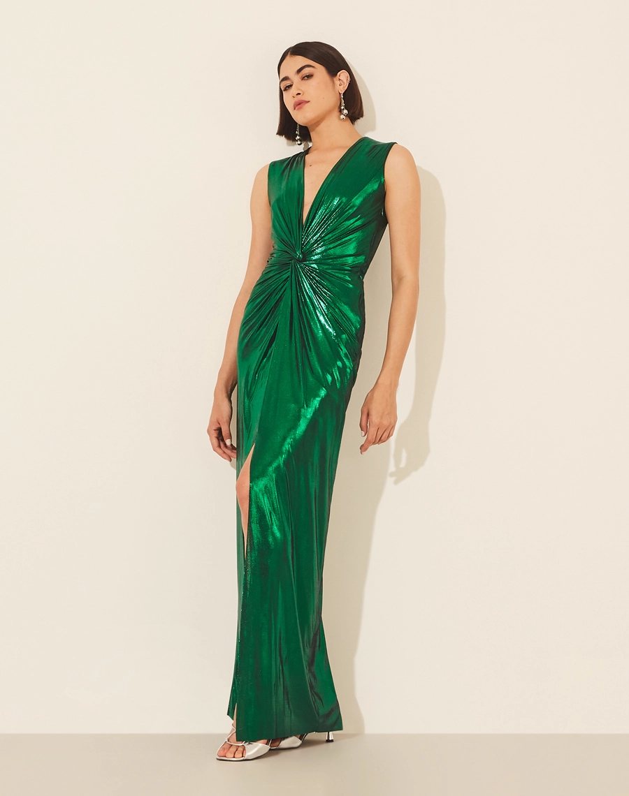 Vestido Lamê Oscar confeccionado em Malha Foil,  possuí decote V com detalhe torcido até a cintura.<br/>
Com forro curto e saia com fenda. Possui modelagem mais justa e seu fechamento é por zíper invisível lateral.