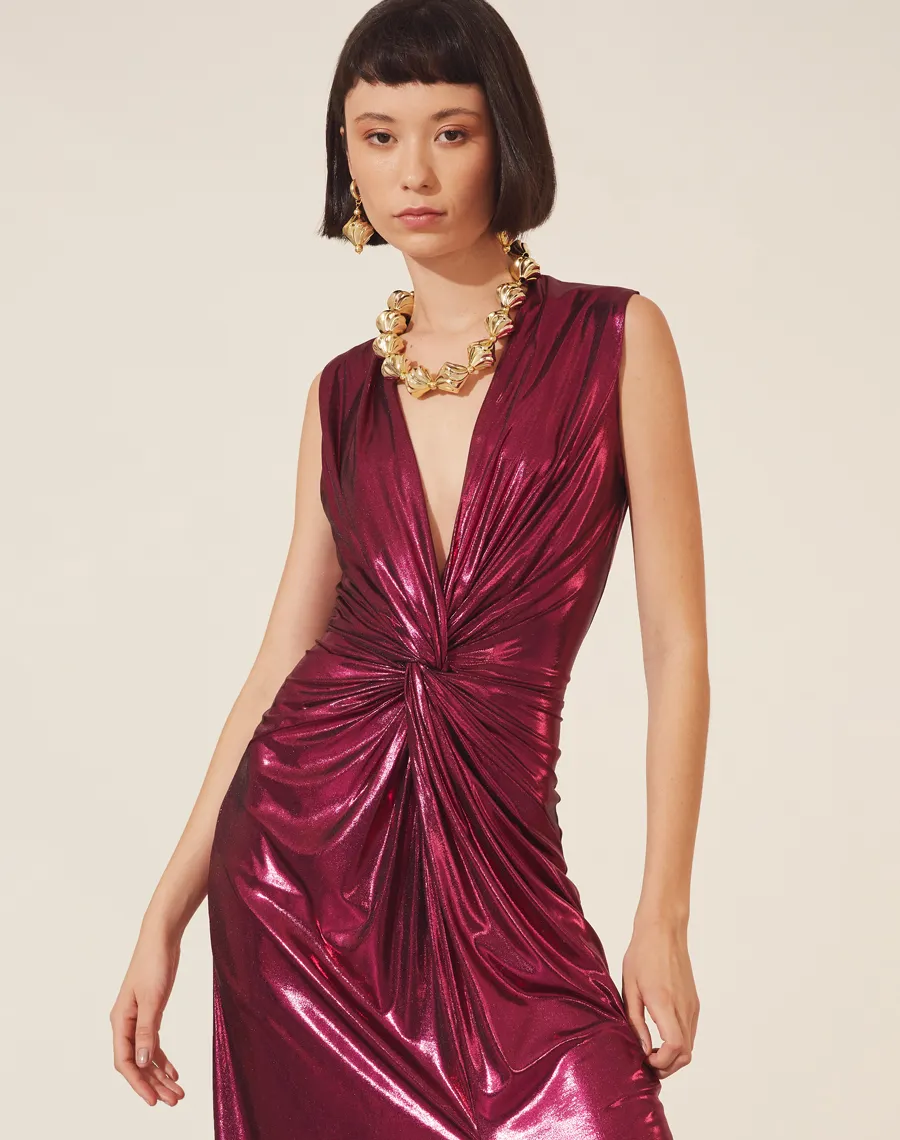 Vestido Lamê Oscar confeccionado em Malha Foil,  possuí decote V com detalhe torcido até a cintura.<br/>
Com forro curto e saia com fenda. Possui modelagem mais justa e seu fechamento é por zíper invisível lateral.