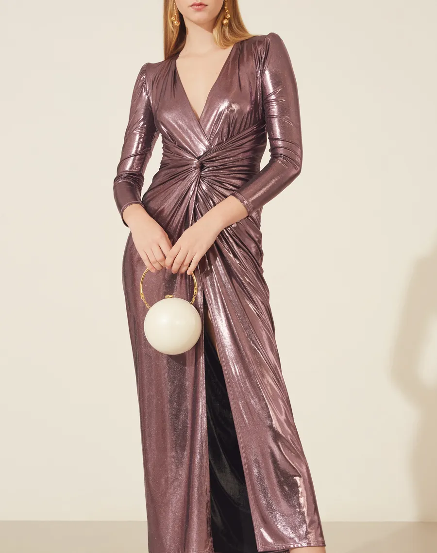 Vestido Longo Foil Jolie confeccionado em lamê, seu decote em V com detalhe torcido. <br/>
Possui forro curto com fenda frontal. <br/>
Seu fechamento é por zíper invisível lateral.<br/>