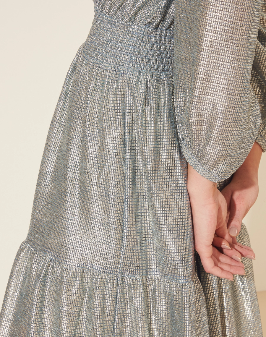 Vestido Longo Desirée confeccionado em Malha Lamê. <br/>
Possui decote V, manga longa bufante e elástico na cintura. <br/>
Vestido acinturado. <br/>