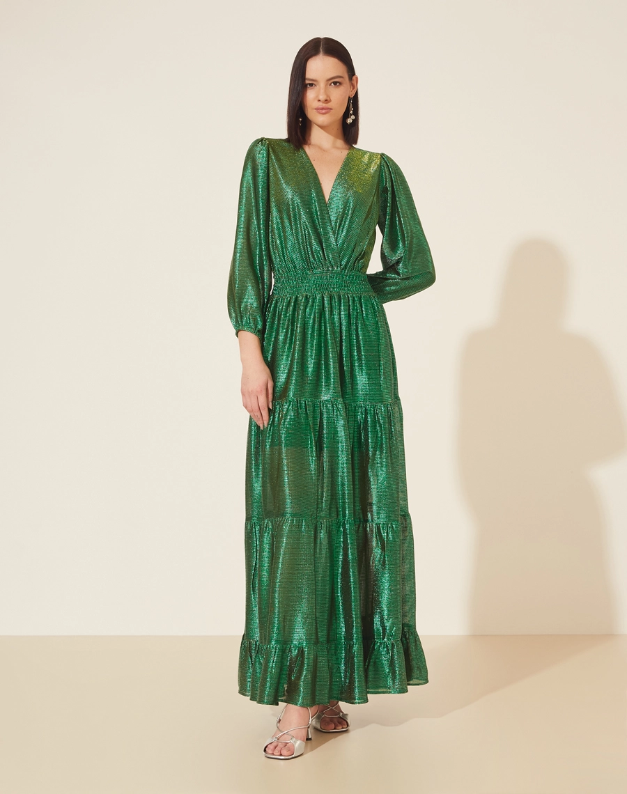 Vestido Longo Desirée confeccionado em Malha Lamê. <br/>
Possui decote V, manga longa bufante e elástico na cintura. <br/>
Vestido acinturado. <br/>