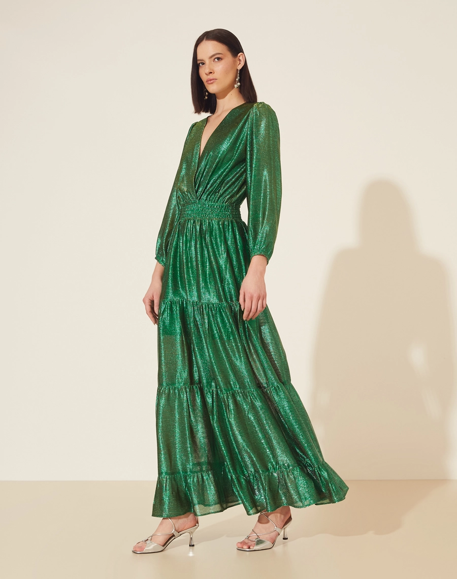 Vestido Longo Desirée confeccionado em Malha Lamê. <br/>
Possui decote V, manga longa bufante e elástico na cintura. <br/>
Vestido acinturado. <br/>