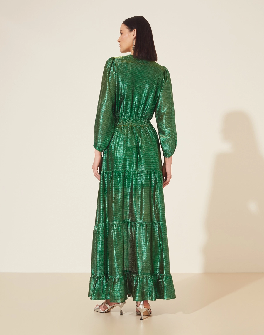 Vestido Longo Desirée confeccionado em Malha Lamê. <br/>
Possui decote V, manga longa bufante e elástico na cintura. <br/>
Vestido acinturado. <br/>