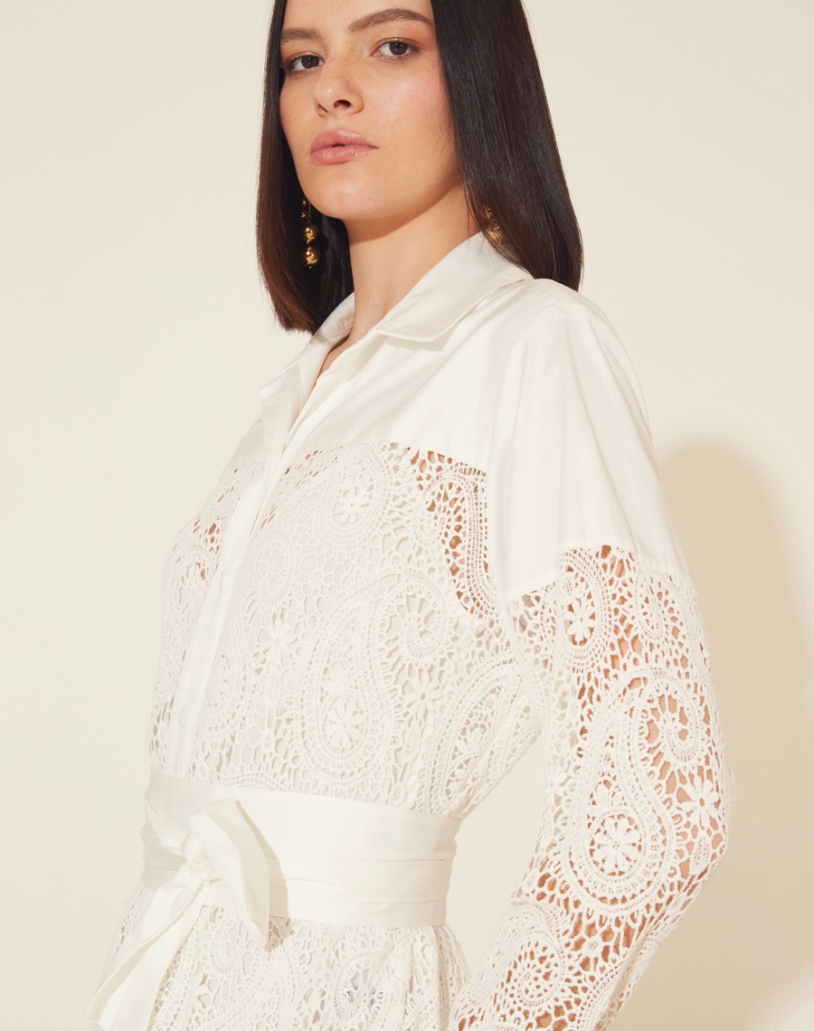 Chemise Longo Mia confeccionado em Renda de algodão, com gola esportiva. Feita em modelagem ampla, comprimento longo e fechamento por abotoamento frontal.
