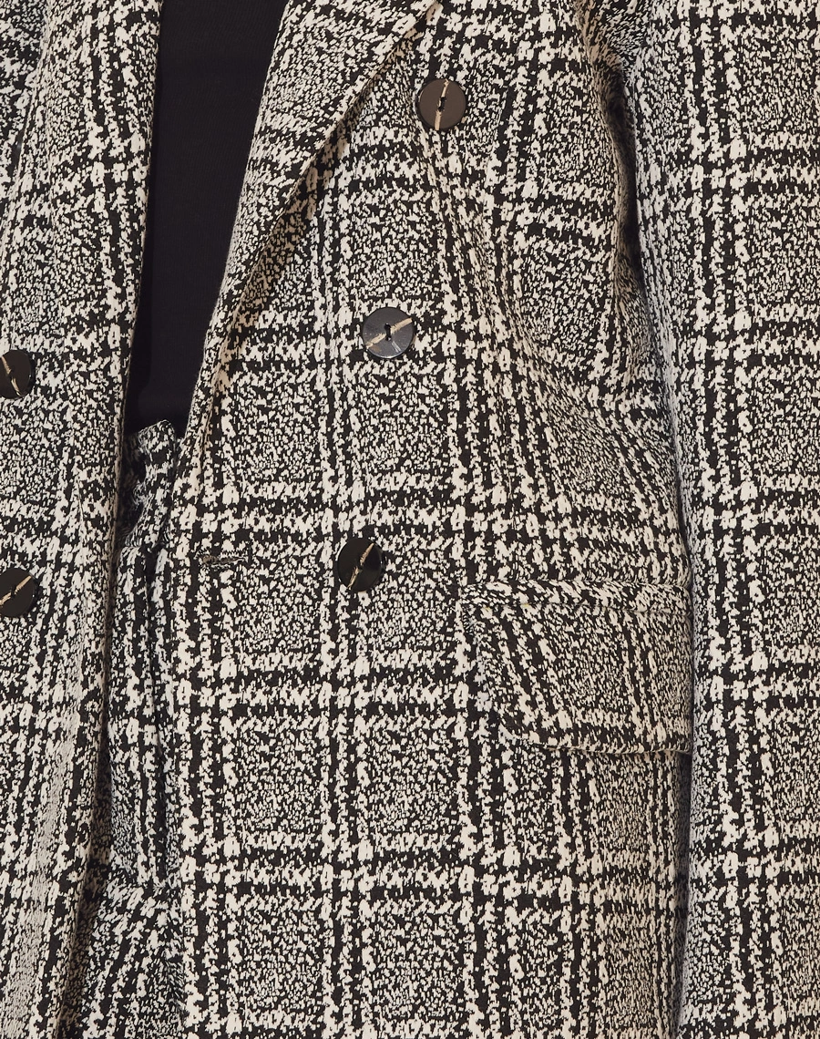 Blazer Anabela confeccionado em Tweed de malha. <br>
Possui forro, golas clássicas, ombros estruturados e dois bolsos decorativos com lapelas. <br>
Fechamento frontal por botões.