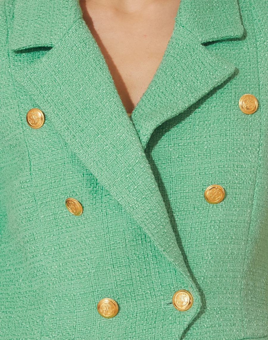 Blazer Royana confeccionado em Tweed. <br/>
Possui forro, golas clássicas e dois bolsos decorativos com lapelas. <br/>
Seu fechamento é por botão dourado. <br/>
