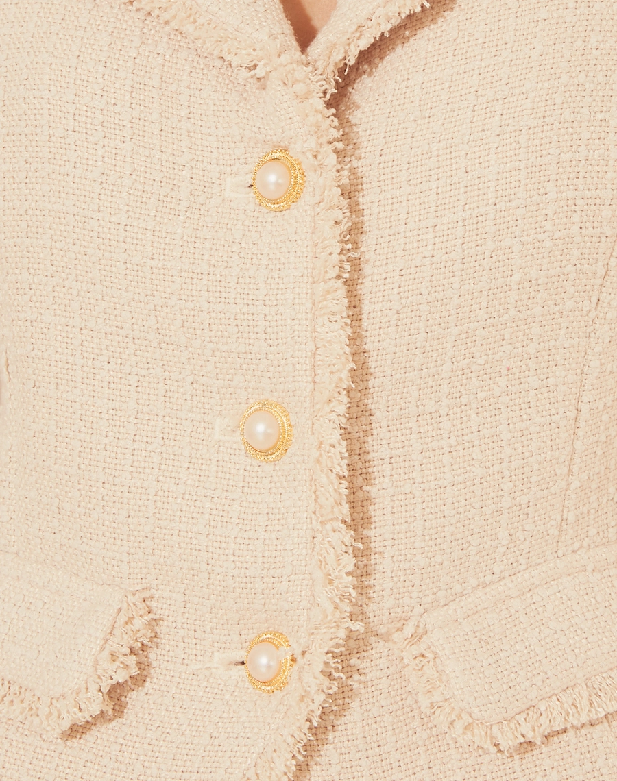 Casaco Jackie confeccionada em tweed, com golas e detalhes de textura felpuda.
Possui forro e botões dourados decorativos com pérolas. <br/>