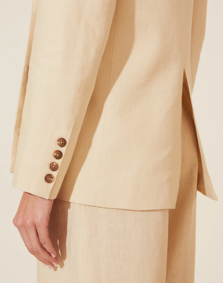 Blazer Manuela confeccionado em linho. Possui golas clássicas, mangas longas e ombreiras para dar mais estrutura nos ombros. 