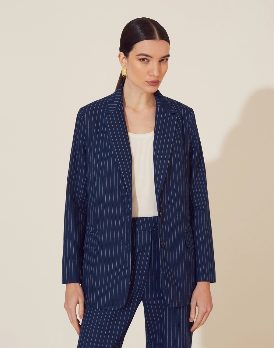 Blazer Marjorie confeccionado em Jeans em risca de giz.  <br>
Possui forro, golas clássicas e dois bolsos decorativos com lapelas em sua frente. <br>