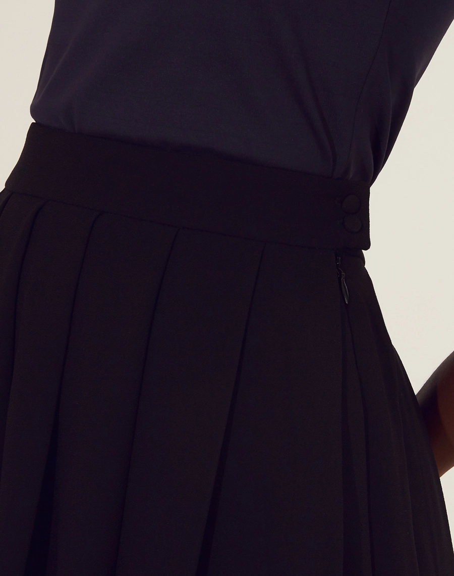 Saia Kity confeccionada em  Crepe Zara. <br/>
Sua cintura é alta, com pregas, modelagem evasê e barra reta.<br/>
Fechamento por zíper invisivel lateral. <br/>