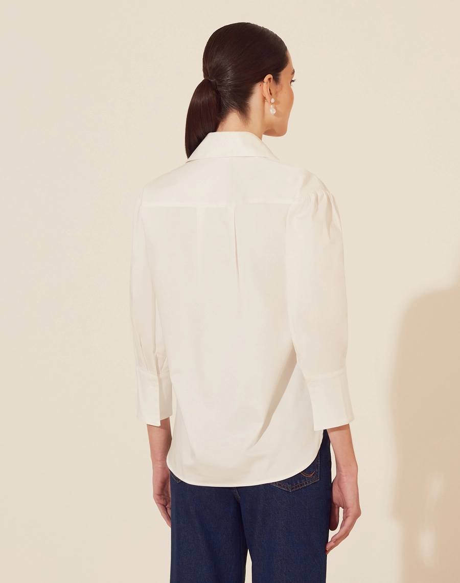 Camisa Encanto confeccionada em Tricoline Acetinado. <br/>
Possui gola esporte, manhas 3/4 e modelagem ampla. <br/>