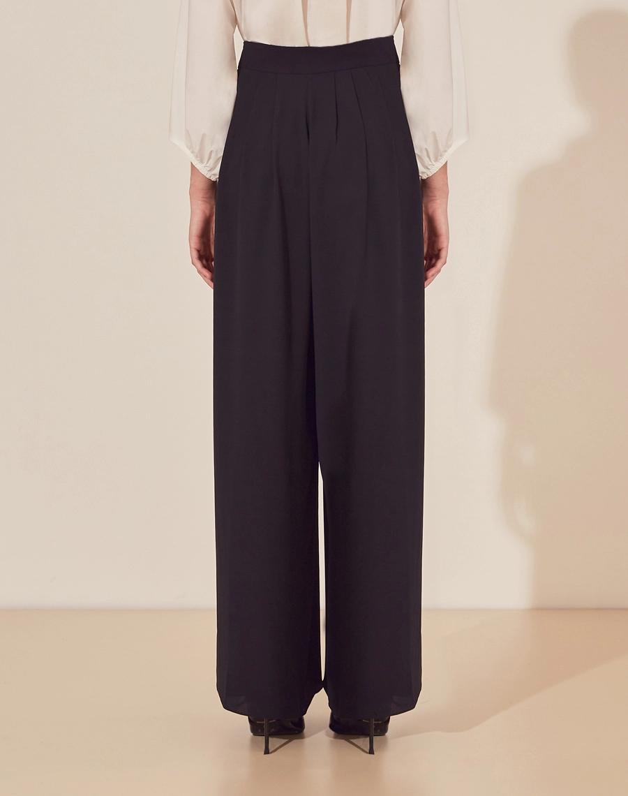 Calça Clarice confeccionada em Crepe Bibi. <br/>
Possui modelagem ampla com caimento leve.<br/>
Possui pregas e seu fechamento é por ziper invísivel na frente.<br/>