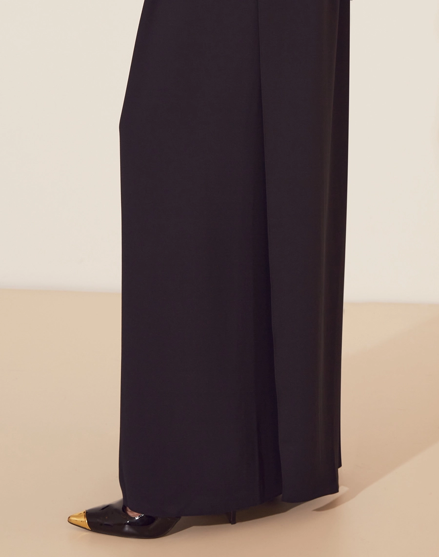 Calça Clarice confeccionada em Crepe Bibi. <br/>
Possui modelagem ampla com caimento leve.<br/>
Possui pregas e seu fechamento é por ziper invísivel na frente.<br/>