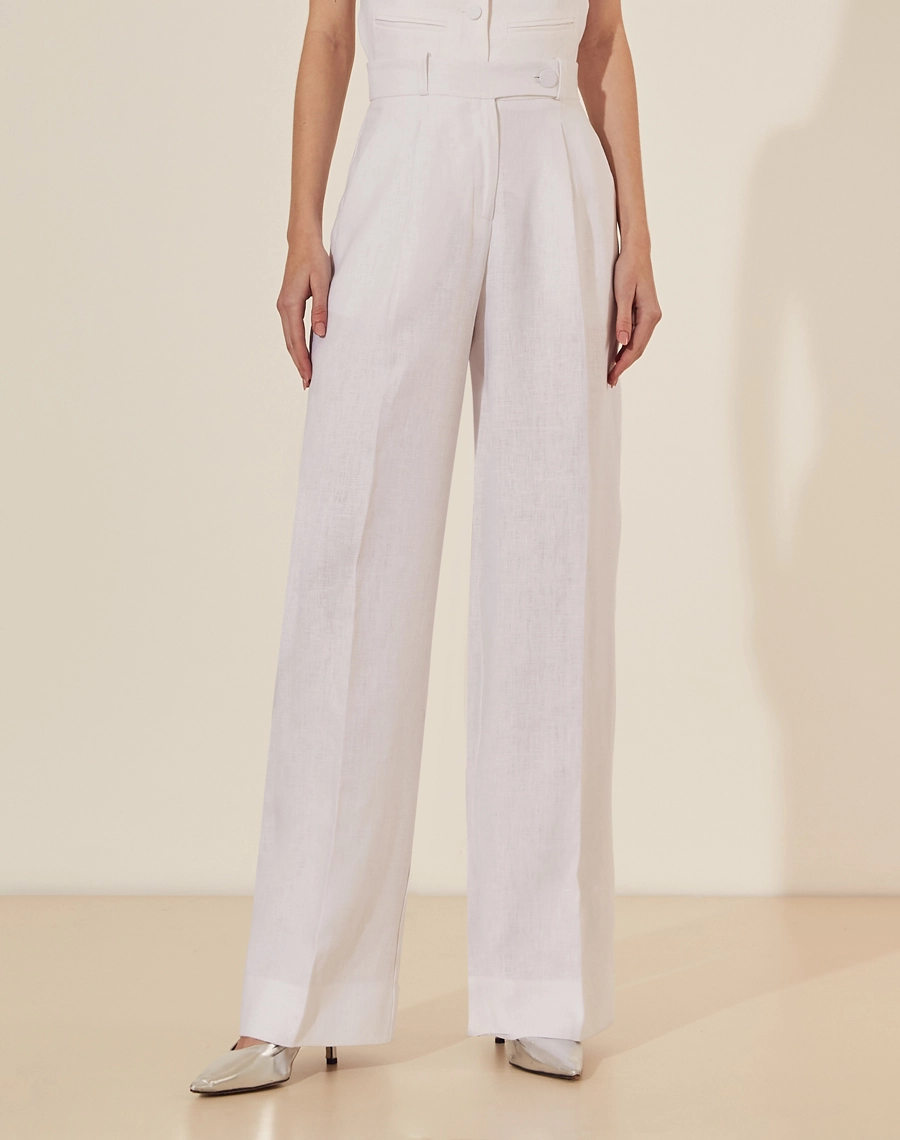 Calça Eugenia, confeccionado em linho, um tecido estruturado com toque rústico. Com modelagem pantalona, bolsos laterais estilo faca e bolsos decorativos atrás.
