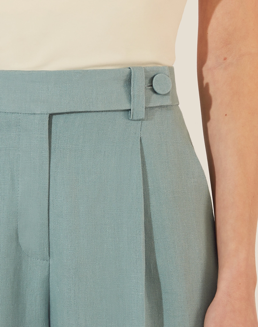 Calça Eugenia, confeccionado em linho, um tecido estruturado com toque rústico. Com modelagem pantalona, bolsos laterais estilo faca e bolsos decorativos atrás.