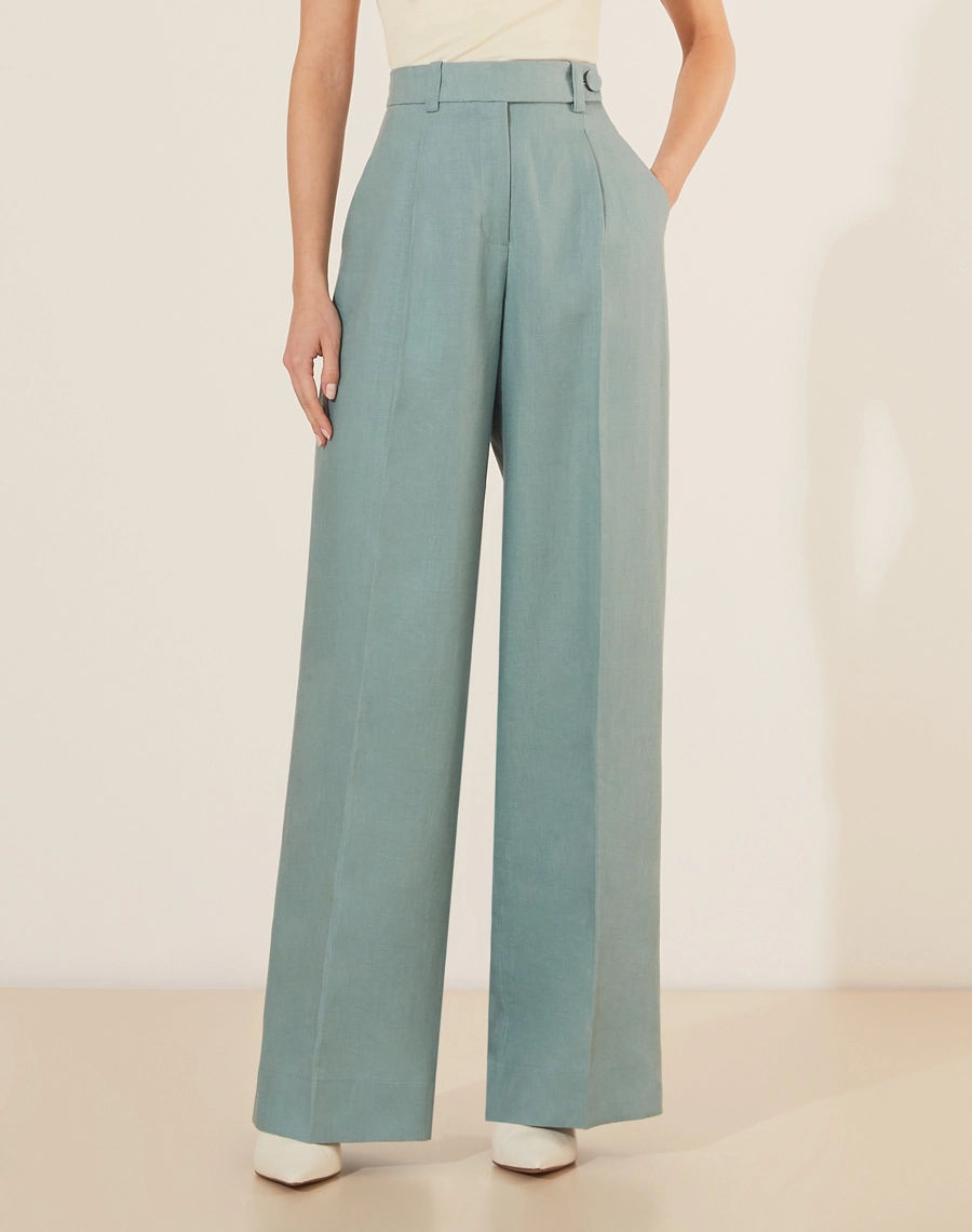 Calça Eugenia, confeccionado em linho, um tecido estruturado com toque rústico. Com modelagem pantalona, bolsos laterais estilo faca e bolsos decorativos atrás.