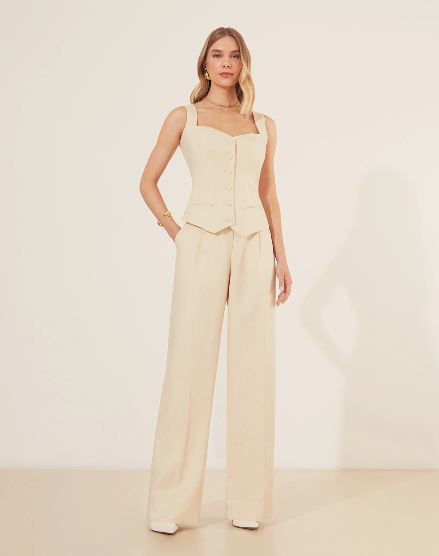 Calça Eugenia, confeccionado em linho, um tecido estruturado com toque rústico. Com modelagem pantalona, bolsos laterais estilo faca e bolsos decorativos atrás.