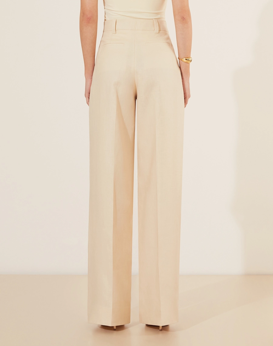 Calça Eugenia, confeccionado em linho, um tecido estruturado com toque rústico. Com modelagem pantalona, bolsos laterais estilo faca e bolsos decorativos atrás.