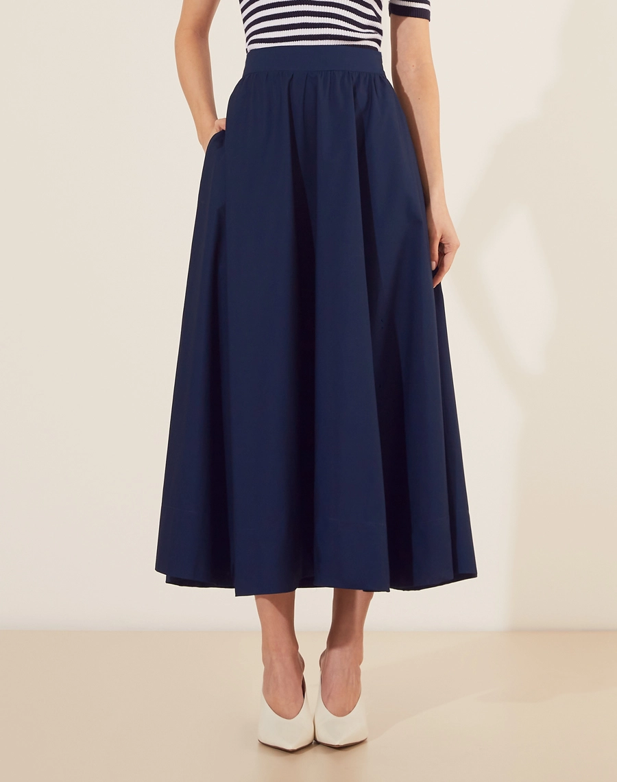 Saia Midi Yasmin confeccionada em Tricoline. <br/>
Sua cintura é alta, com pregas, modelagem evasê e barra reta.<br/>
Fechamento por zíper invisivel lateral. <br/>