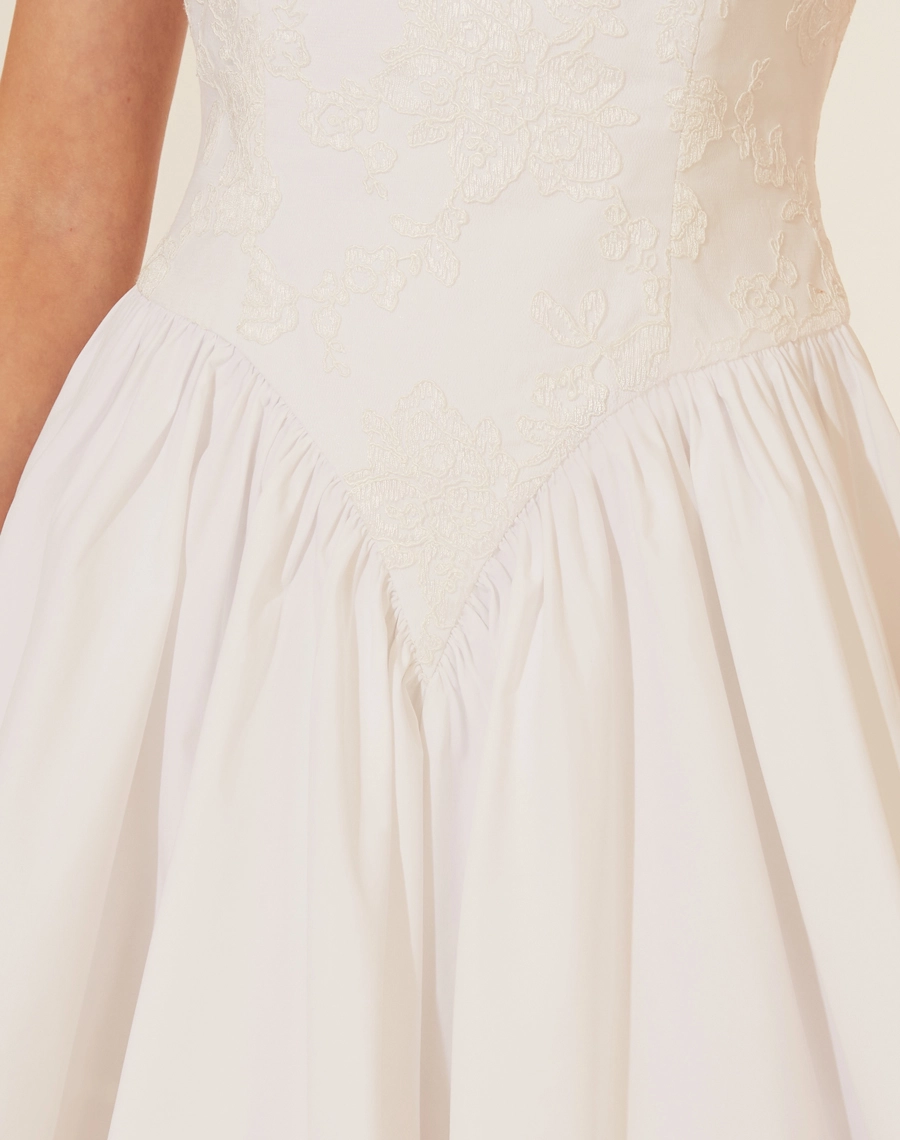 Vestido Curto Brigitte, confeccionado em Renda delicada,o vestido possui decote reto e alças finas, além de um corpete com amarração em fitas de cetim nas costas, proporcionando um ajuste perfeito. <br/>
A saia curta e volumosa adiciona um toque jovial e elegante à peça.<br/>
Fechamento por zíper.<br/>