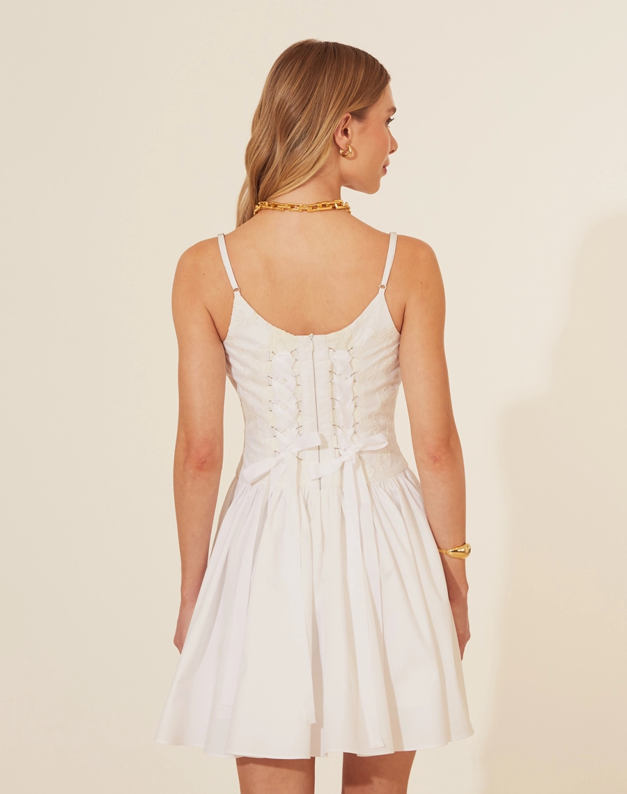 Vestido Curto Brigitte, confeccionado em Renda delicada,o vestido possui decote reto e alças finas, além de um corpete com amarração em fitas de cetim nas costas, proporcionando um ajuste perfeito. <br/>
A saia curta e volumosa adiciona um toque jovial e elegante à peça.<br/>
Fechamento por zíper.<br/>