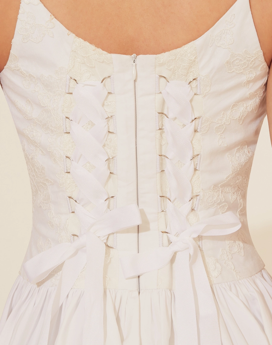 Vestido Curto Brigitte, confeccionado em Renda delicada,o vestido possui decote reto e alças finas, além de um corpete com amarração em fitas de cetim nas costas, proporcionando um ajuste perfeito. <br/>
A saia curta e volumosa adiciona um toque jovial e elegante à peça.<br/>
Fechamento por zíper.<br/>