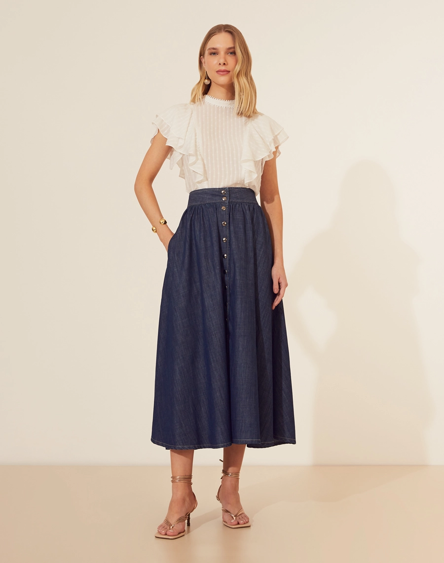 Saia Midi Bonnard confeccionada em Jeans, possui modelagem evasê (ampla), cintura alta e dois bolsos laterais estilo faca. 