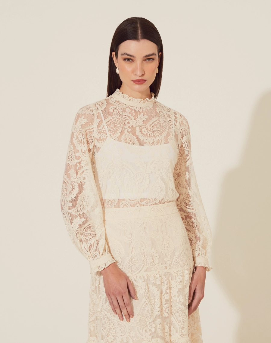 Blusa Belle Epoque é confeccionada em Renda delicada, trazendo uma estética romântica e atemporal. Com mangas longas e gola alta, o modelo é perfeito para compor looks elegantes e sofisticados.