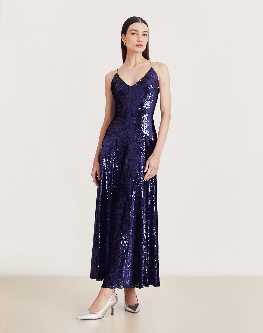 Vestido longo de paetê com alças cruzadas, decote em V e caimento fluido. Glamour e conforto para festas e eventos sofisticados.