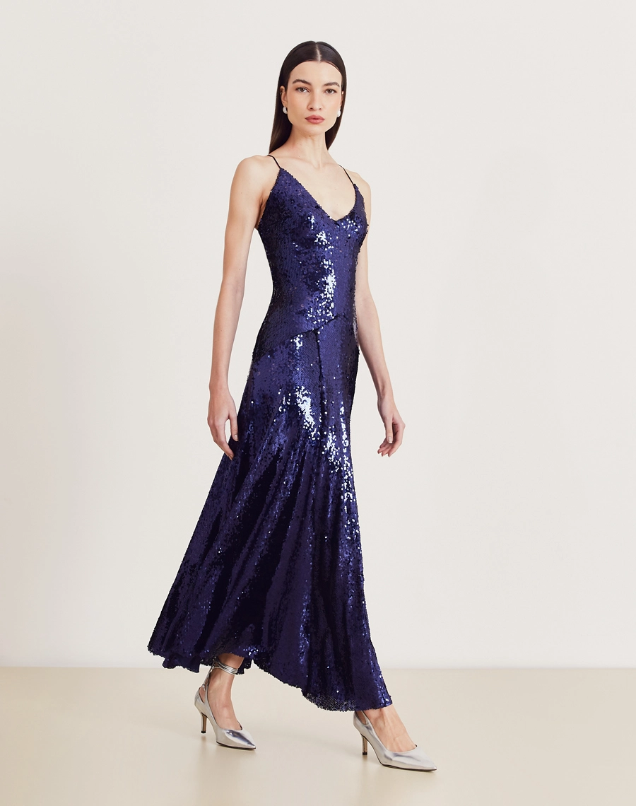 Vestido longo de paetê com alças cruzadas, decote em V e caimento fluido. Glamour e conforto para festas e eventos sofisticados.