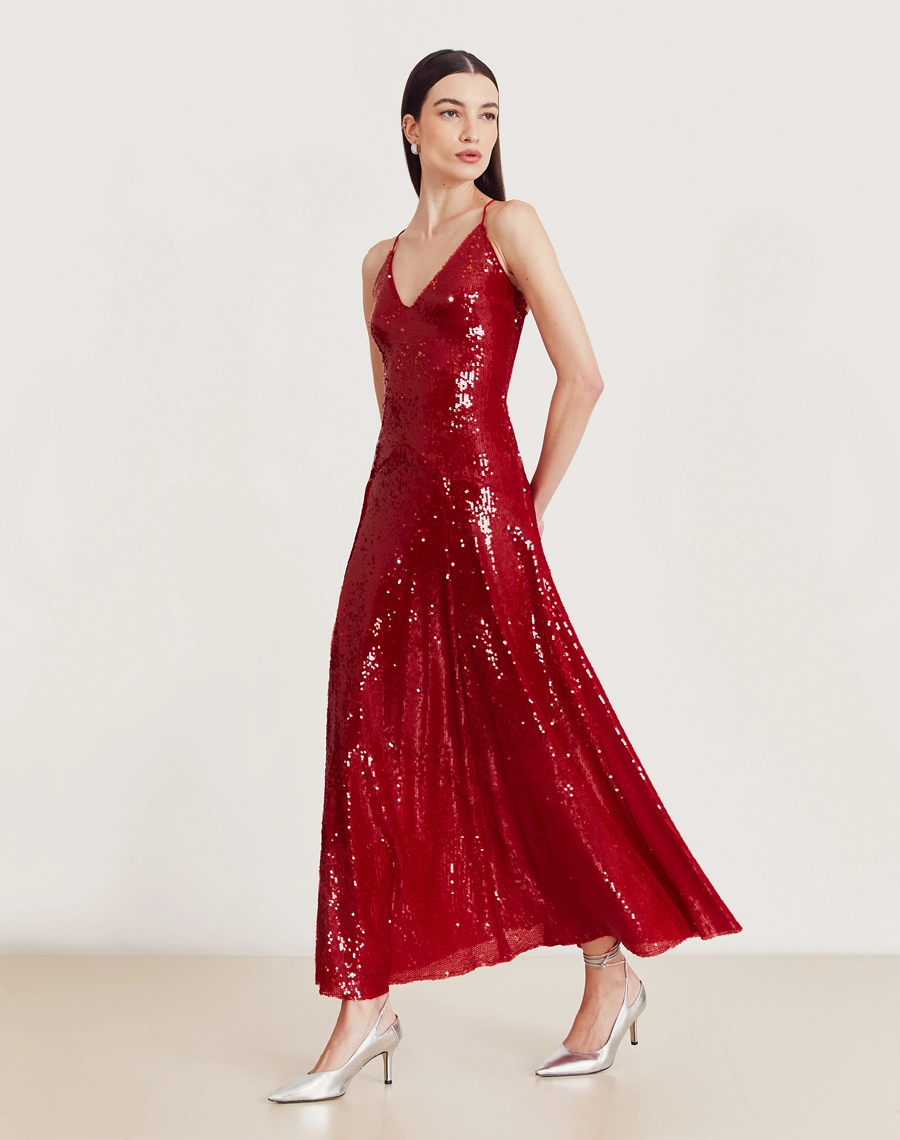 Vestido longo de paetê com alças cruzadas, decote em V e caimento fluido. Glamour e conforto para festas e eventos sofisticados.