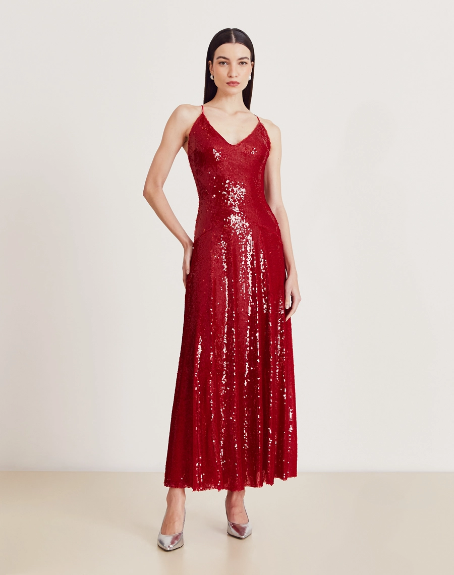 Vestido longo de paetê com alças cruzadas, decote em V e caimento fluido. Glamour e conforto para festas e eventos sofisticados.