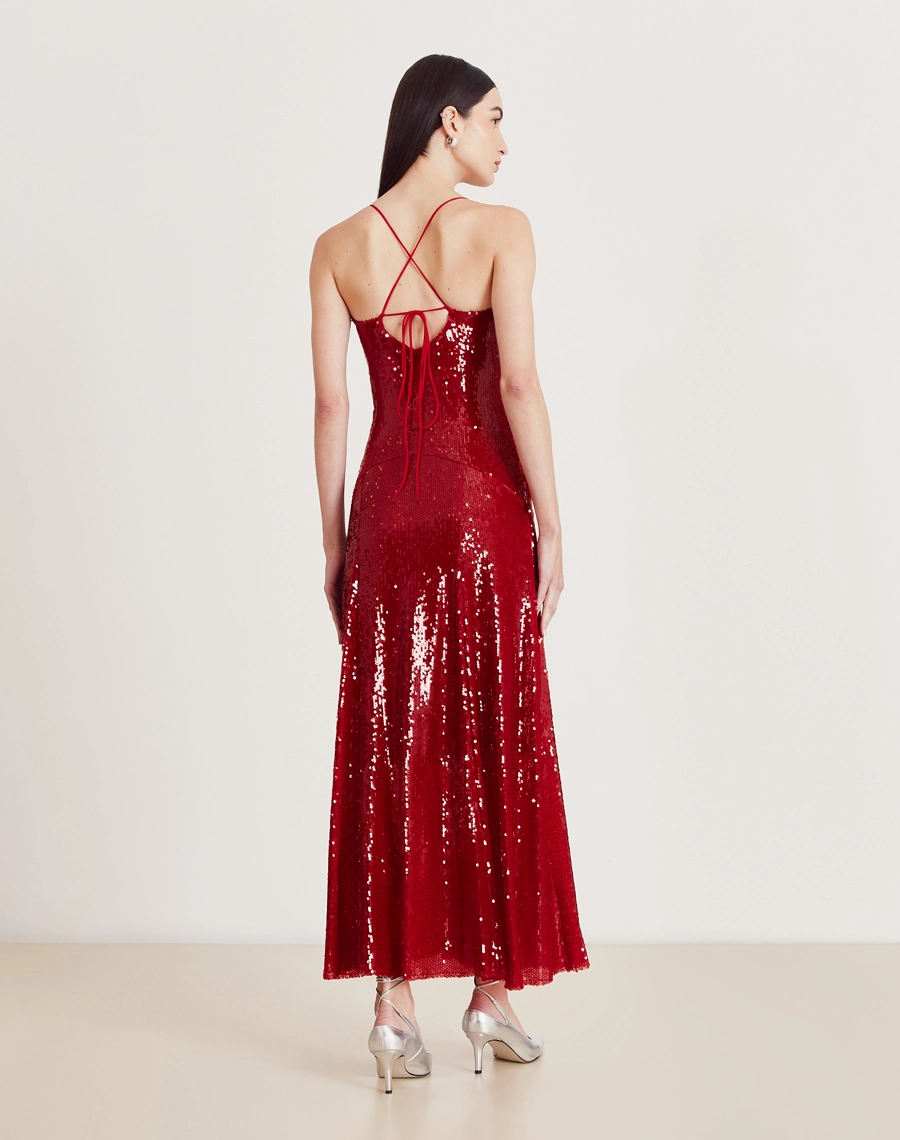Vestido longo de paetê com alças cruzadas, decote em V e caimento fluido. Glamour e conforto para festas e eventos sofisticados.