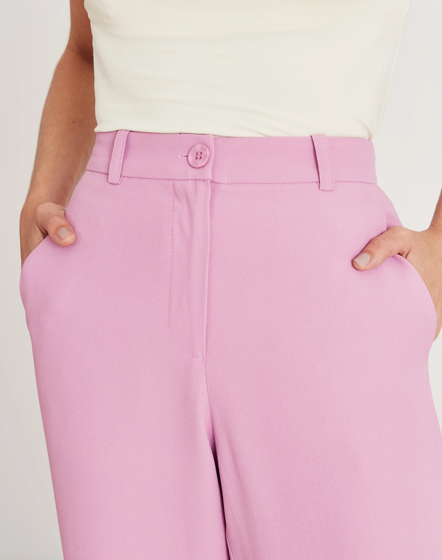 A Calça Vitória é confeccionada em crepe patou. Indispensável para quem busca um visual elegante e versátil, a Calça Vitória é perfeita para transitar facilmente entre reuniões de trabalho e eventos sociais, tanto de dia quanto à noite.
