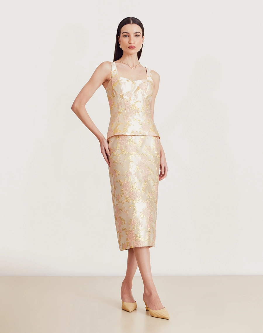 Vestido midi em jacquard com folhas douradas, decote coração, peplum e fenda traseira. Elegante e confortável para eventos especiais.

