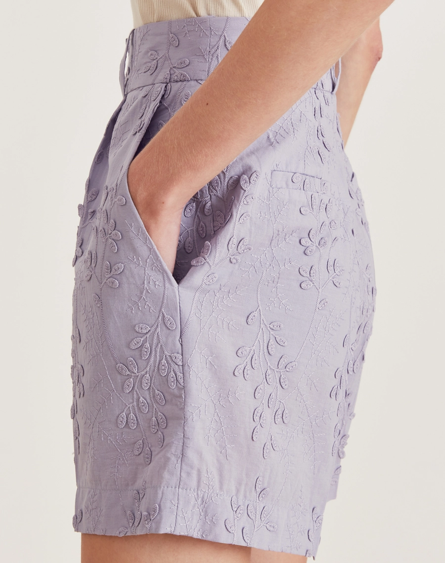 O Shorts Ariane é confeccionado em cambraia bordada, tecido leve e fresco que é perfeito para os dias mais quentes. As folhas bordadas trazem um toque delicado, tornando o modelo perfeito para quem busca um visual moderno e atemporal. Ideal para brunchs, passeios ao ar livre ou eventos diurnos.