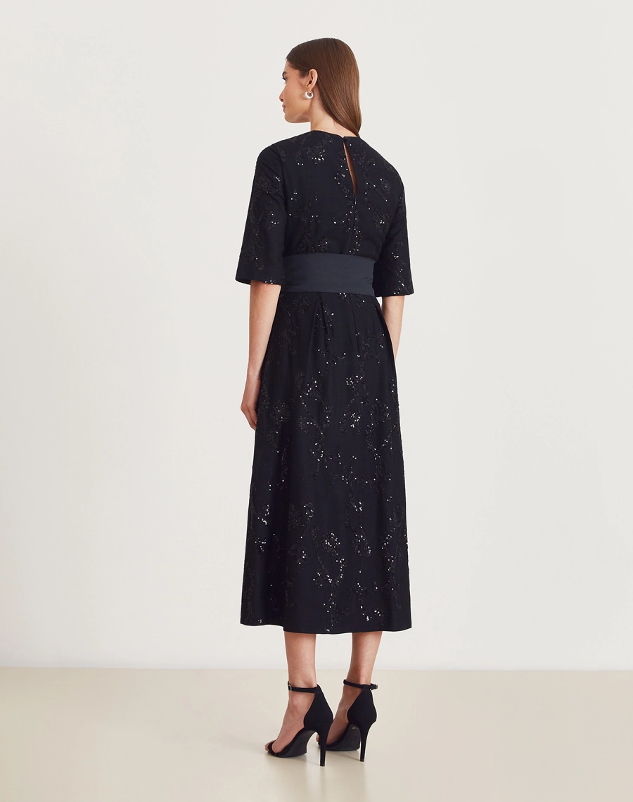 Vestido midi de linho bordado com mangas 3/4, faixa e brilho sutil. Elegância clássica para eventos, festas, casamentos e ocasiões especiais.