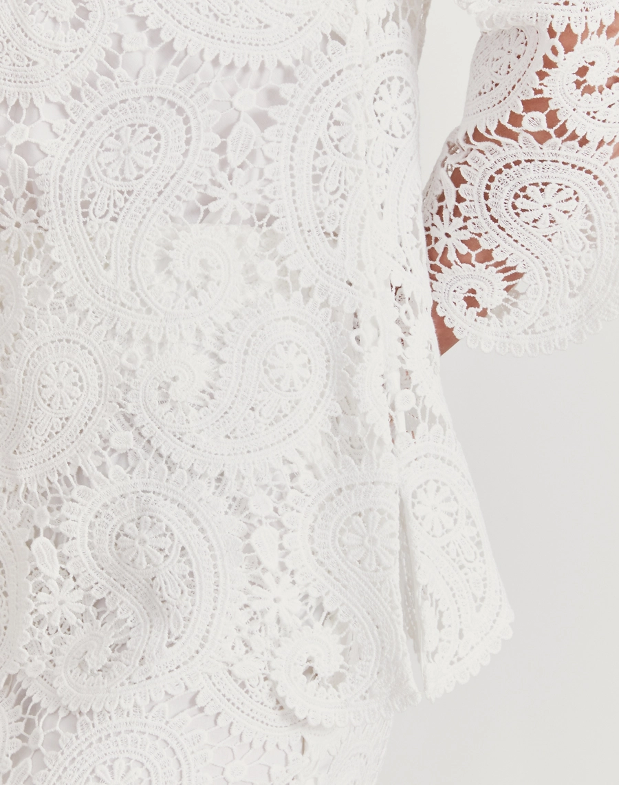 A Blusa Trancoso é confeccionada em renda de algodão, garantindo toque macio, caimento leve e sofisticação natural. É ideal para ocasiões especiais ao ar livre, celebrações diurnas ou looks resort chic elegantes e frescos.