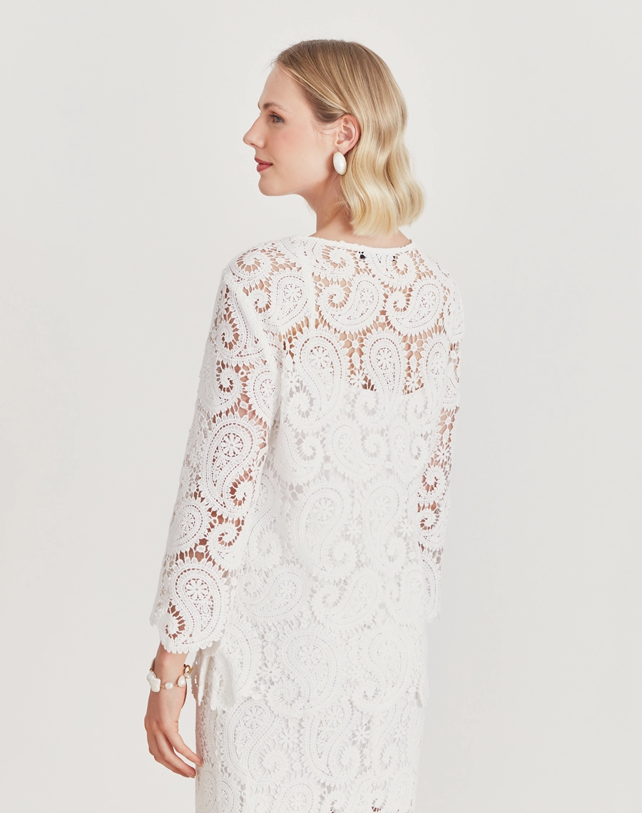 A Blusa Trancoso é confeccionada em renda de algodão, garantindo toque macio, caimento leve e sofisticação natural. É ideal para ocasiões especiais ao ar livre, celebrações diurnas ou looks resort chic elegantes e frescos.